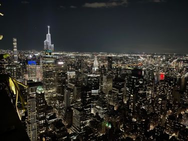 Vue de nuit sur le Chrysler Building au centre et l'insigne Pepsi-Cola à gauche